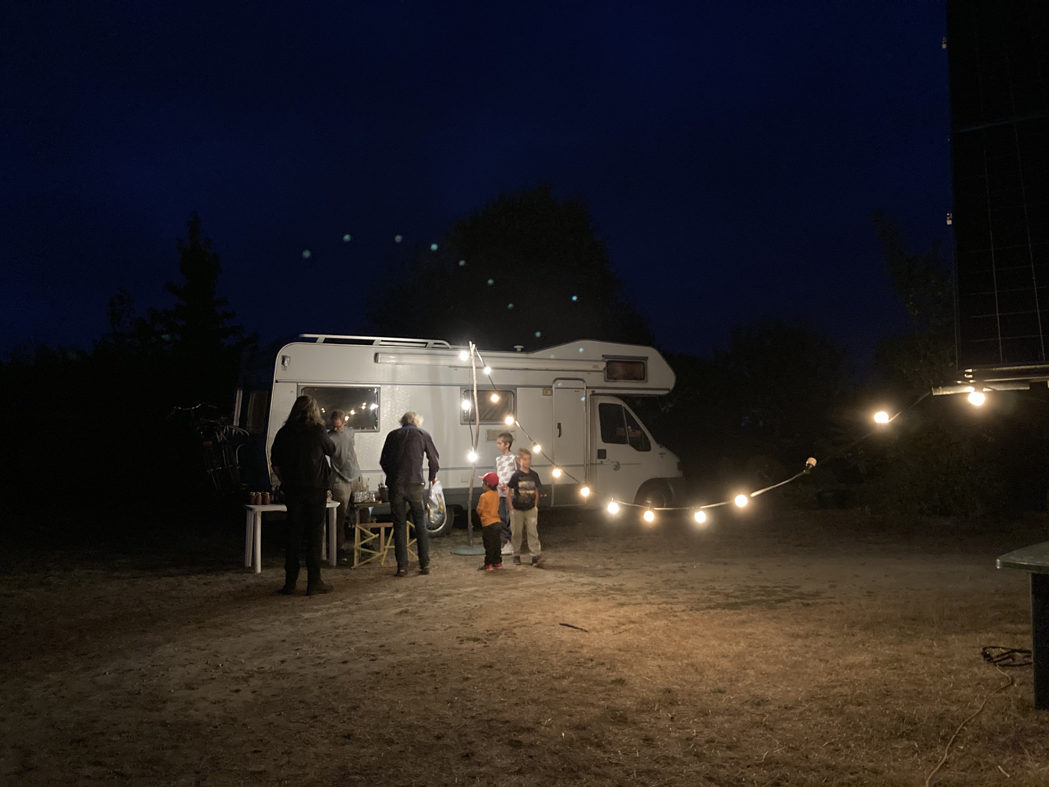 A string of lights connected to a campervan at night, where we had the outdoor cinema night