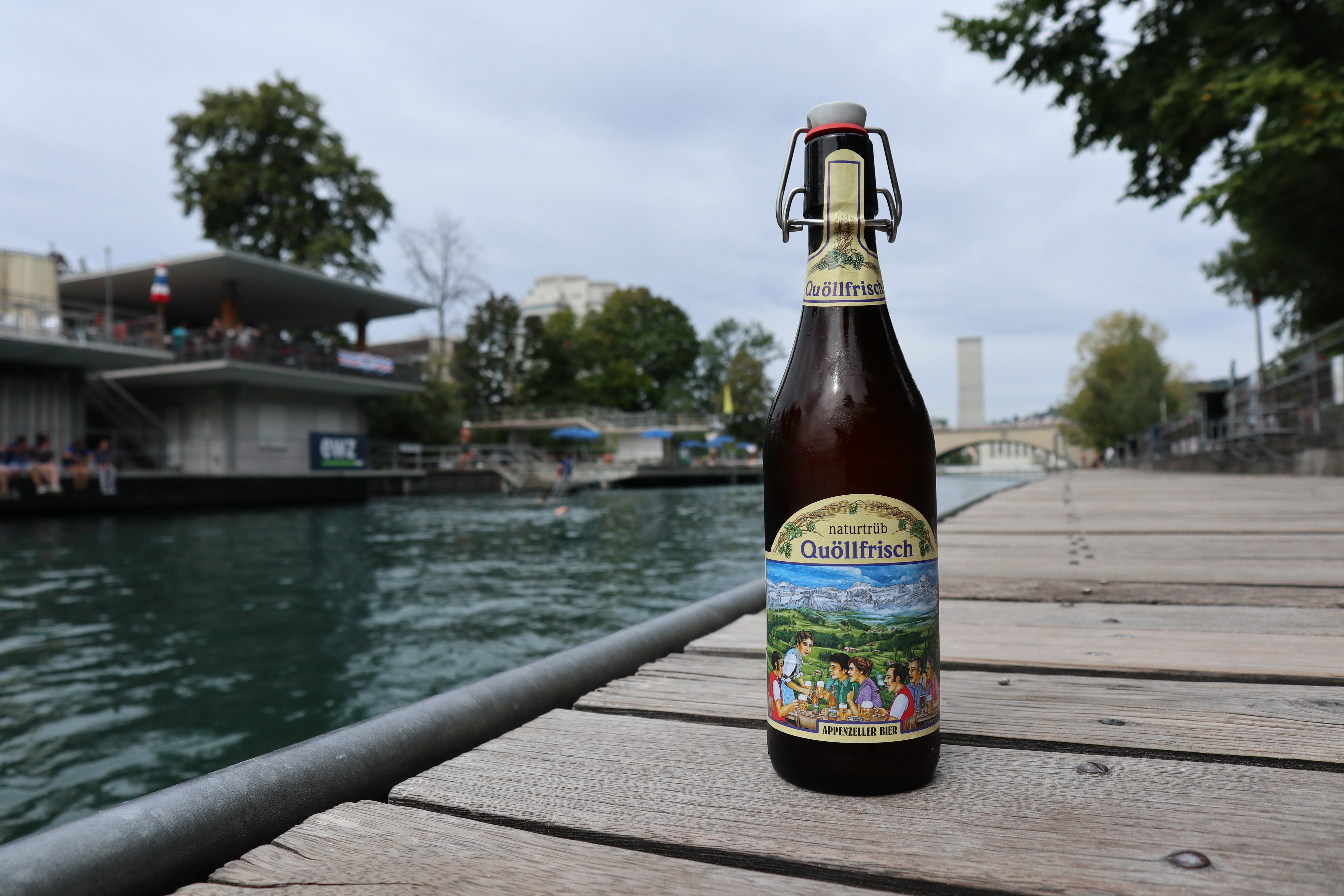 A beer bottle next to the river Limmat