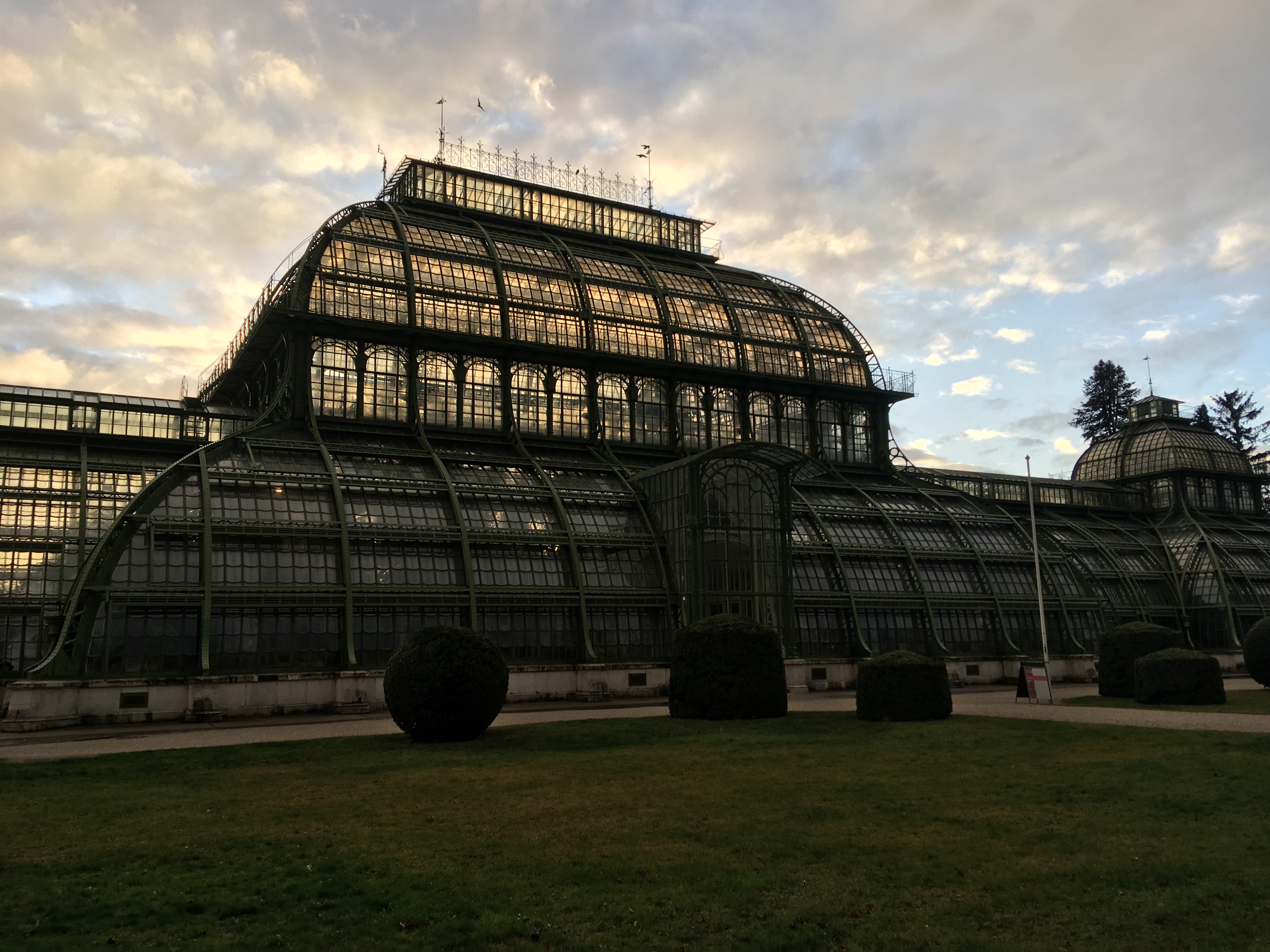The exterior of a green house in a park in Vienna